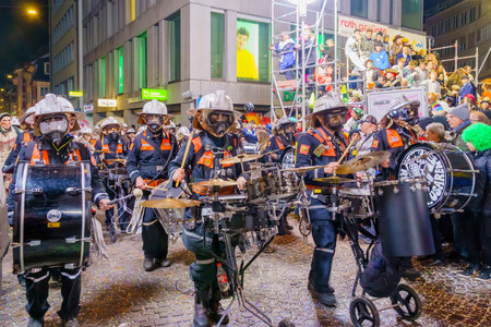 Lucerne, Switzerland - February 21, 2023: Band of musicians in costumes march in the streets, part of the final night parade of the Fasnacht Carnival, in Lucerne (Luzern), Switzerlandのeditorial素材