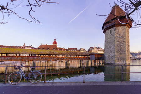 Lucerne, Switzerland - February 21, 2023: Sunrise view of the Chapel Bridge, and the Reuss River and various buildings, in Lucerne (Luzern), Switzerlandのeditorial素材