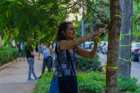 Haifa, Israel - October 26, 2023: People hang yellow ribbon on trees, as a symbolic call to bring back the people kidnapped to Gaza. Haifa, Israelのeditorial素材