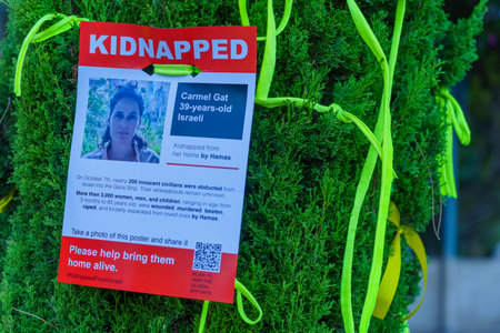 Haifa, Israel - October 26, 2023: Posters of people kidnapped to Gaza, and yellow ribbons on trees,...