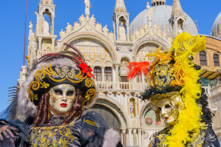 Venice, Italy - March 01, 2022: Couple dressed in traditional costumes stand in front of the Ducal palace, part of the Venice Mask Carnival, Veneto, Italyのeditorial素材