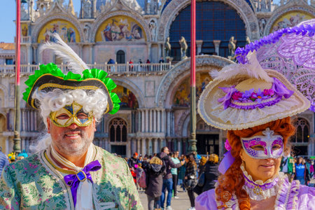 Venice, Italy - February 28, 2022: Couple dressed in traditional costumes, in St. Marks Square, part of the Venice Mask Carnival, Veneto, Italyのeditorial素材