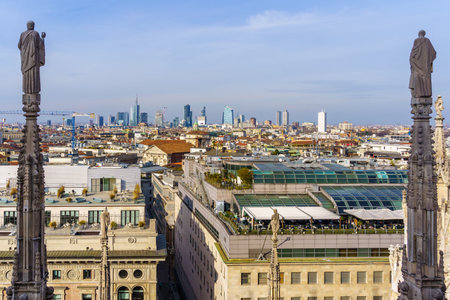 Milan, Italy - March 02, 2022: View from the Cathedral (Duomo) terraces on the city, with statues, various buildings, locals and visitors, in Milan, Lombardy, Northern Italyのeditorial素材