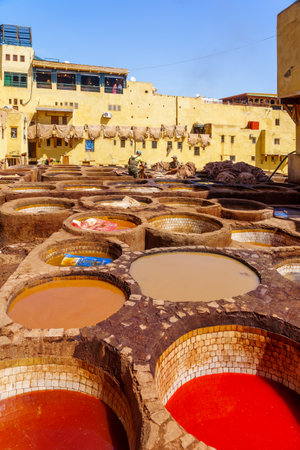 Fes, Morocco - March 31, 2023: Scene of the leather tannery with stone vats filled with various colors, and workers. Fes, Moroccoのeditorial素材