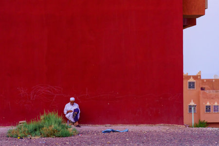 Ouarzazate, Morocco - April 03, 2023: Sunset view of red wall and a local at the end of a Ramadan day, in Ouarzazate, Moroccoのeditorial素材