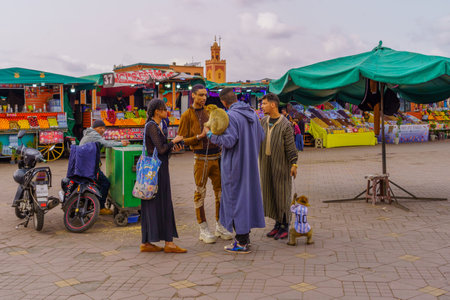 Marrakesh, Morocco - April 05, 2023: Scene of the Jemaa el-Fnaa square, with various stalls, locals,...