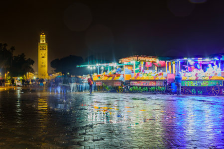 Marrakesh, Morocco - April 04, 2023: Rainy night scene of the Jemaa el-Fnaa square, with various stalls, locals, and visitors, in Marrakesh, Moroccoのeditorial素材