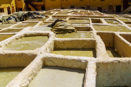 Fes, Morocco - March 31, 2023: View of the leather tannery with stone vats filled with various colors, and workers. Fes, Moroccoのeditorial素材