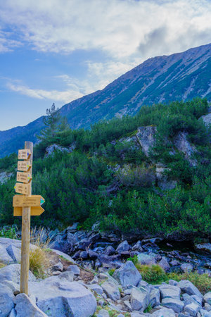 View of mountain landscape in Pirin National Park, with directional signs (park symbol and bilingual path name), in southwestern Bulgariaの写真素材