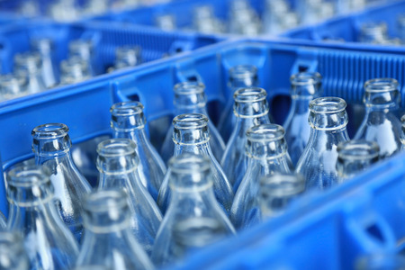 Blue Plastic Crate with Empty Glass Bottlesの写真素材