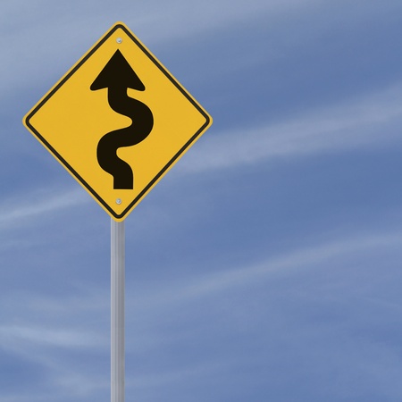 Winding road ahead sign on a blue sky background with copy space の写真素材