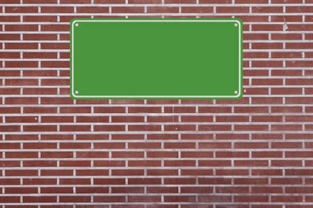 Blank sign mounted on a brick wall の写真素材