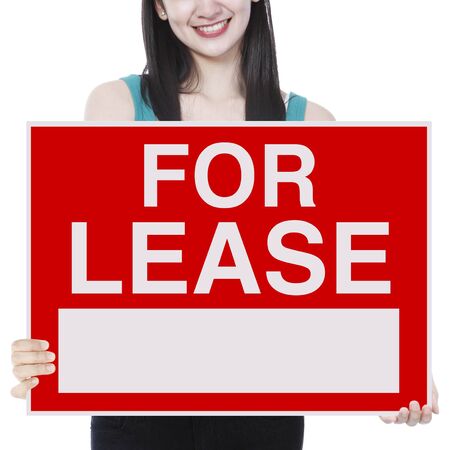 A young woman holding a signboard indicating For Lease の写真素材