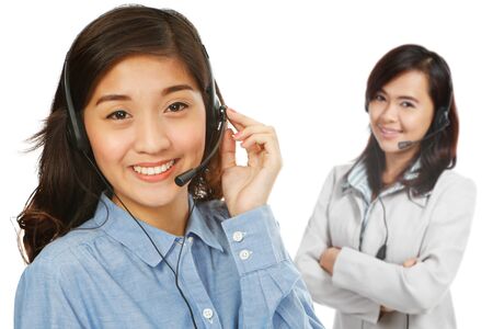 Two young women wearing headsets (on white background) の写真素材