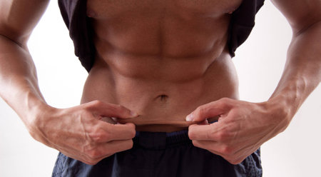 A man pulling the skin over his abdominalsの写真素材