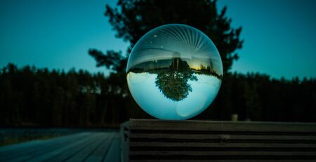Reflection of Tree in Crystal Ball on Beautiful Autumn Evening with Great Colors