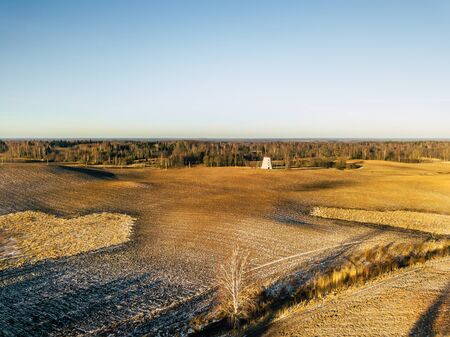Aerial Drone Photography of a Sunny Winter Day with a Beautiful Winter Colors of the Fields and Windmill in the Backgroundの写真素材