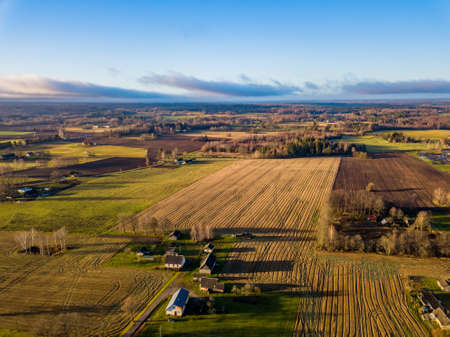 Aerial Drone Photography of a Meadows in a Countryside Village Surrounded in Beautiful Autumn Colorsの写真素材