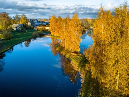 Aerial Photo of a Lake in Sunny Autumn Day with a View over the Village and an Island in the Middle of the Lakeの写真素材