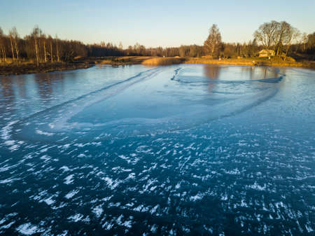 Beautiful Photo of a Frozen Lake in Sunny Autumn Day in an October, with a Sun Shining at Tree line...