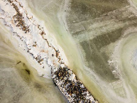 Aerial Photography of Snowy Beach With  Winter Jetty Covered in Ice on a Sunny Winter Dayの写真素材