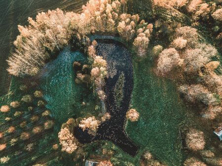 Aerial Drone Photography of a Pond Behind the House Surrounded with Beautiful Autumn Colors of the Fields and Forest - vintage look editの写真素材