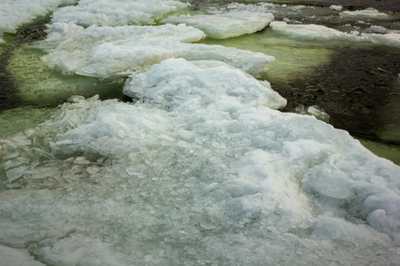 Baltic Sea Beach with Ice Floating in a Water, through Natural Frame of two Snow Piles on a Sunny...