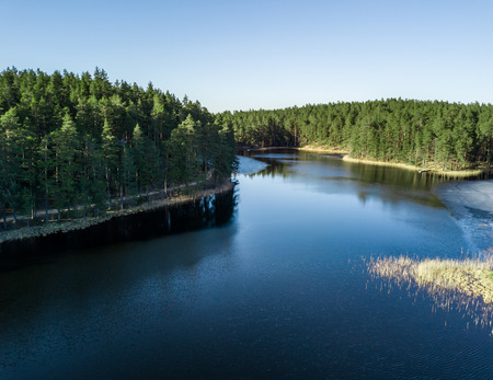 Aerial Drone Photograph of a Partly Frozen Lake in a Snowy Early Springの写真素材