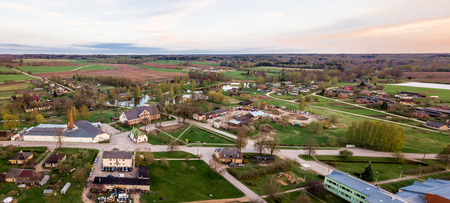 Aerial Drone Photograph of a  Village Surrounded with  Meadows  in Beautiful Spring Colours in Evening with Sunset Over itの写真素材