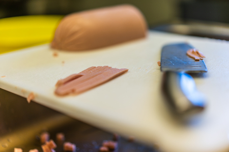 Cutted Halves of Ham, Laying on Table, with The Knife Besides them, Partly Blurredの写真素材
