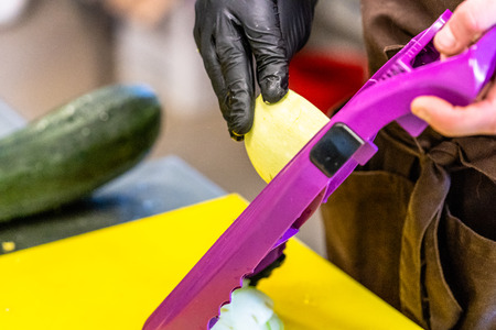 Male Chef Cutting Eggplant in the Kitchen - with Glove on his Hand