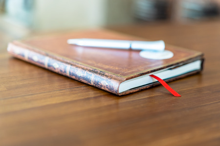 Restaurant Service Notebook on the Table in Hotel Reception -  Dreamy Bokeh Look, Blurred Background, with a Pen on Top of itの写真素材