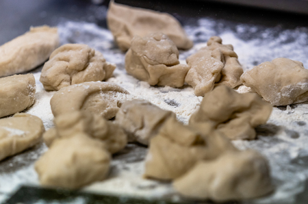 Small Bread Dough Balls Placed on Cooking Paper on Pan - Ready to be Baked, Kitchen Setの写真素材
