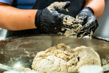 Female Chef Mixing Bread Dough in a Stainless Steel Bowl for Selfmade Bread - Kitchen Set, Wedding Mealの写真素材