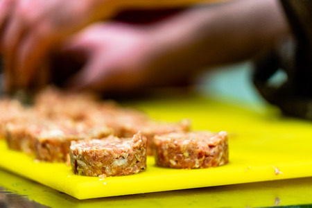 Male Chef Making Round Pork Cutlet for Some Burgers for  Wedding Meal - Kitchen Set, Isolated Action with Chef`s Handsの写真素材