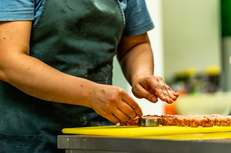 Male Chef Making Round Pork Cutlet for Some Burgers for  Wedding Meal - Kitchen Set, Isolated Action with Chef`s Handsの写真素材