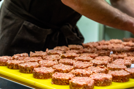 Male Chef Making Round Pork Cutlet for Some Burgers for  Wedding Meal - Kitchen Set, Isolated Action with Chef`s Handsの写真素材