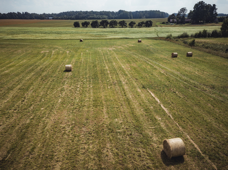 Aerial Drone Photo of Hay Rolls in the Wheat Field, Surrounded with Forests  - Sunny Summer Day, Vintage Look Editの写真素材