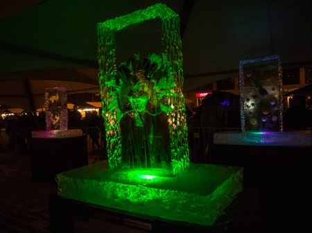 Jelgava / Latvia - February 10th, 2017: Mask frozen into ice sculpture at night of International Ice Sculpture Festival in Jelgava - green lightのeditorial素材