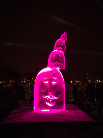 Jelgava / Latvia - February 10th, 2017: Carved face ice sculpture at night of International Ice Sculpture Festival in Jelgava - pink lightのeditorial素材
