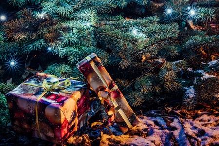Wrapped Christmas Presents Under the Christmas Tree with Lights - Holiday Themeの写真素材