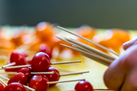 Chopsticks in Little Tomatoes for Small Burgers on the Yellow Chopping Board - Kitchen Setの写真素材