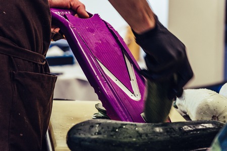 Male Chef Cutting Eggplant in the Kitchen - with Glove on his Hand, Concept of the Hard Working Person and the Hygiene in the Kitchen, Vintage Film Lookの写真素材
