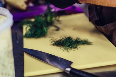 Male Chef Cutting Dill on Yellow Board - Kitchen Set, Vintage Film Lookの写真素材