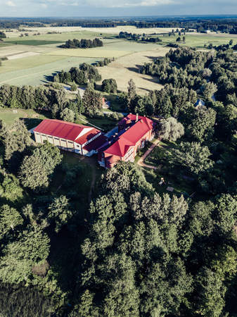 Aerial Photo of Old Castle turned into School in Countryside Between Trees with Dramatic Clouds over it in Early Spring on Sunny Day - Concept of Peaceful Life in Countryside in Harmony, Vintage Lookのeditorial素材