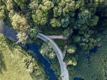 Aerial Photo of Road going by the River under the Trees, Top Down View in Early Spring on Sunny Day - Concept of Peaceful Life in Countryside in Harmony, Vintage Film Lookの写真素材
