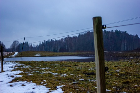 Empty Countryside Landscape in Cloudy Winter Day with Snow Partly Covering the Ground and Fog - Concept of Sadness and Lonelinessの写真素材