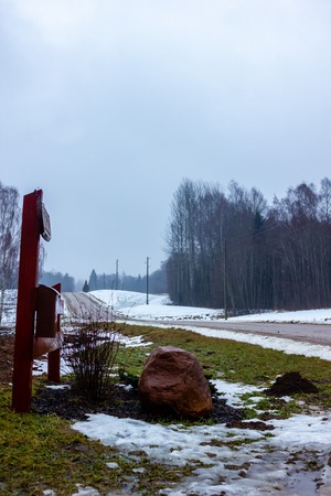 Empty Countryside Landscape in Cloudy Winter Day with Snow Partly Covering the Ground and Fog - Concept of Sadness and Lonelinessの写真素材
