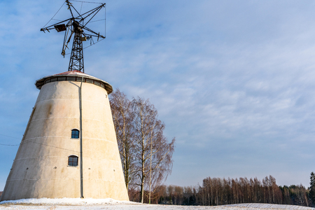 Empty Countryside Landscape in Sunny Winter Day with Snow Covering the Ground with Big Abandoned Windmill in Background - Concept of Fun and Joyの写真素材