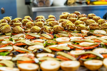 Closeup View of Sliced Bread Spread on the Table with Ingredients on them for Small Burgers - Kitchen Set, Concept of the Holiday Evening Dinner Tableの写真素材
